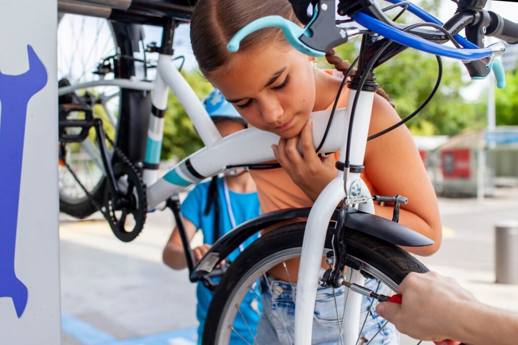A father helps his child fix a bicycle, showcasing teamwork and hands-on learning